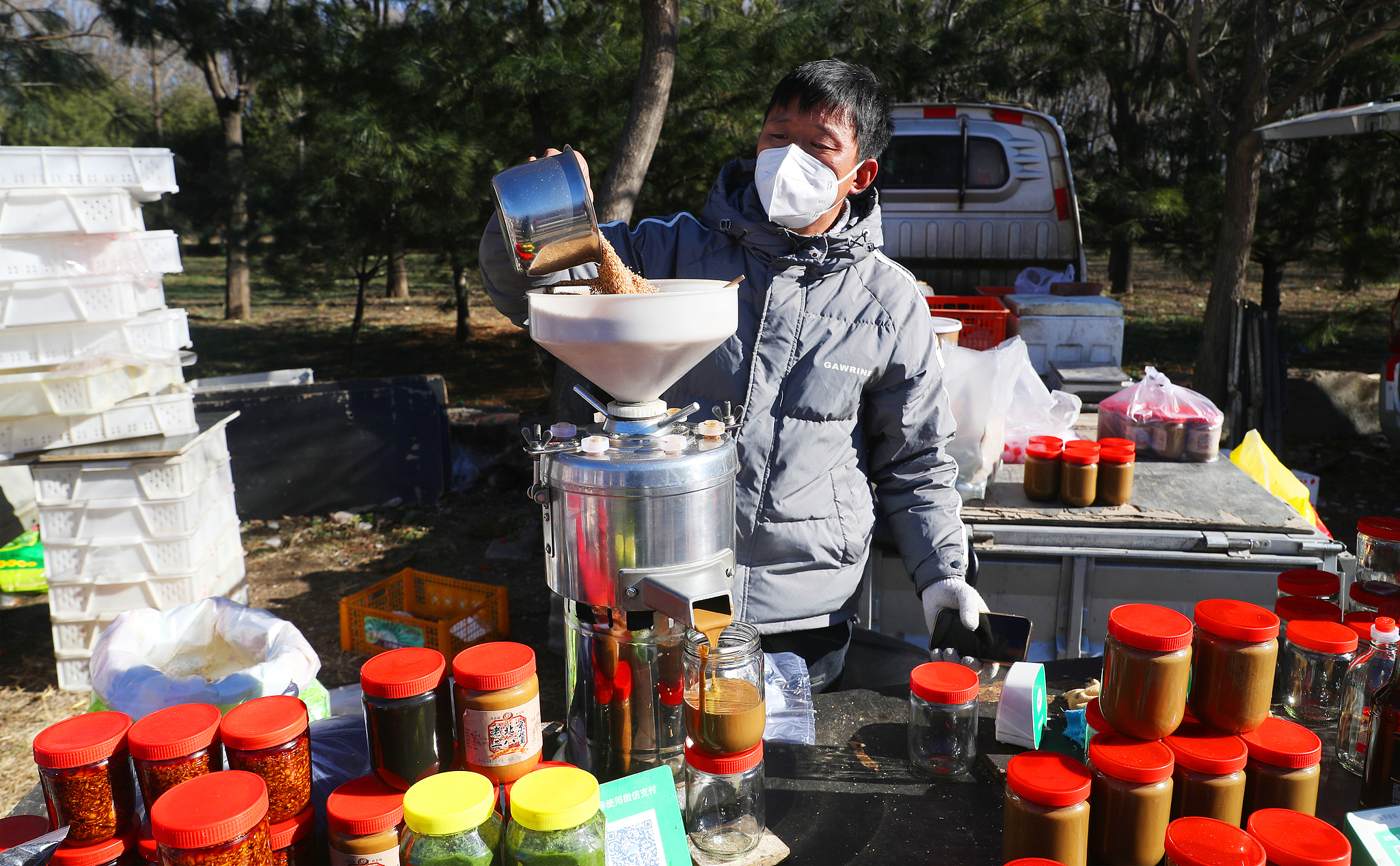 A vendor sells different sauces at a rural open-air market in Huoxian County, Tongzhou District, Beijing, December 2, 2024. /CFP