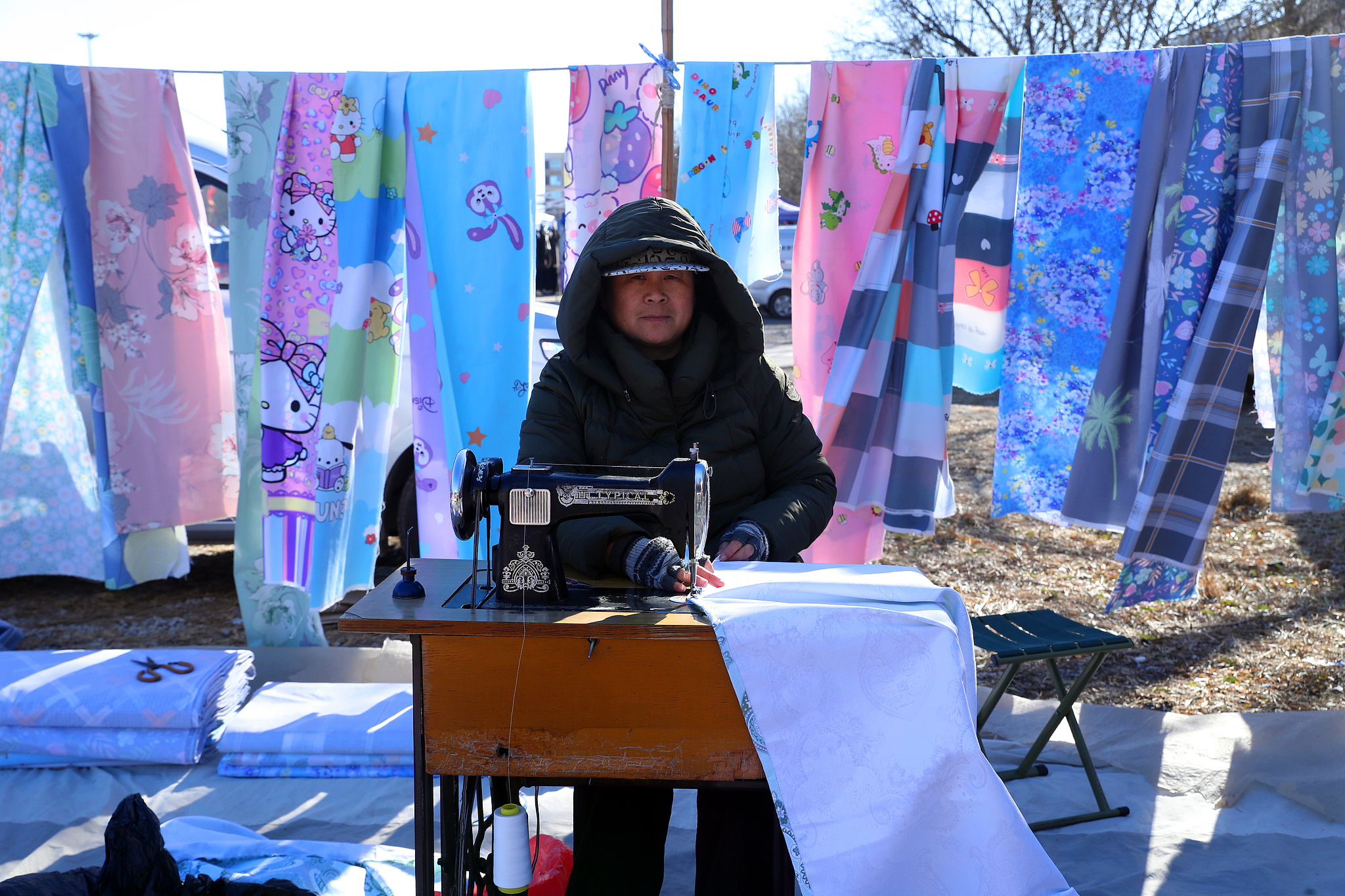 A vendor sells bedding at a rural open-air market in Huoxian County, Tongzhou District, Beijing, December 2, 2024. /CFP