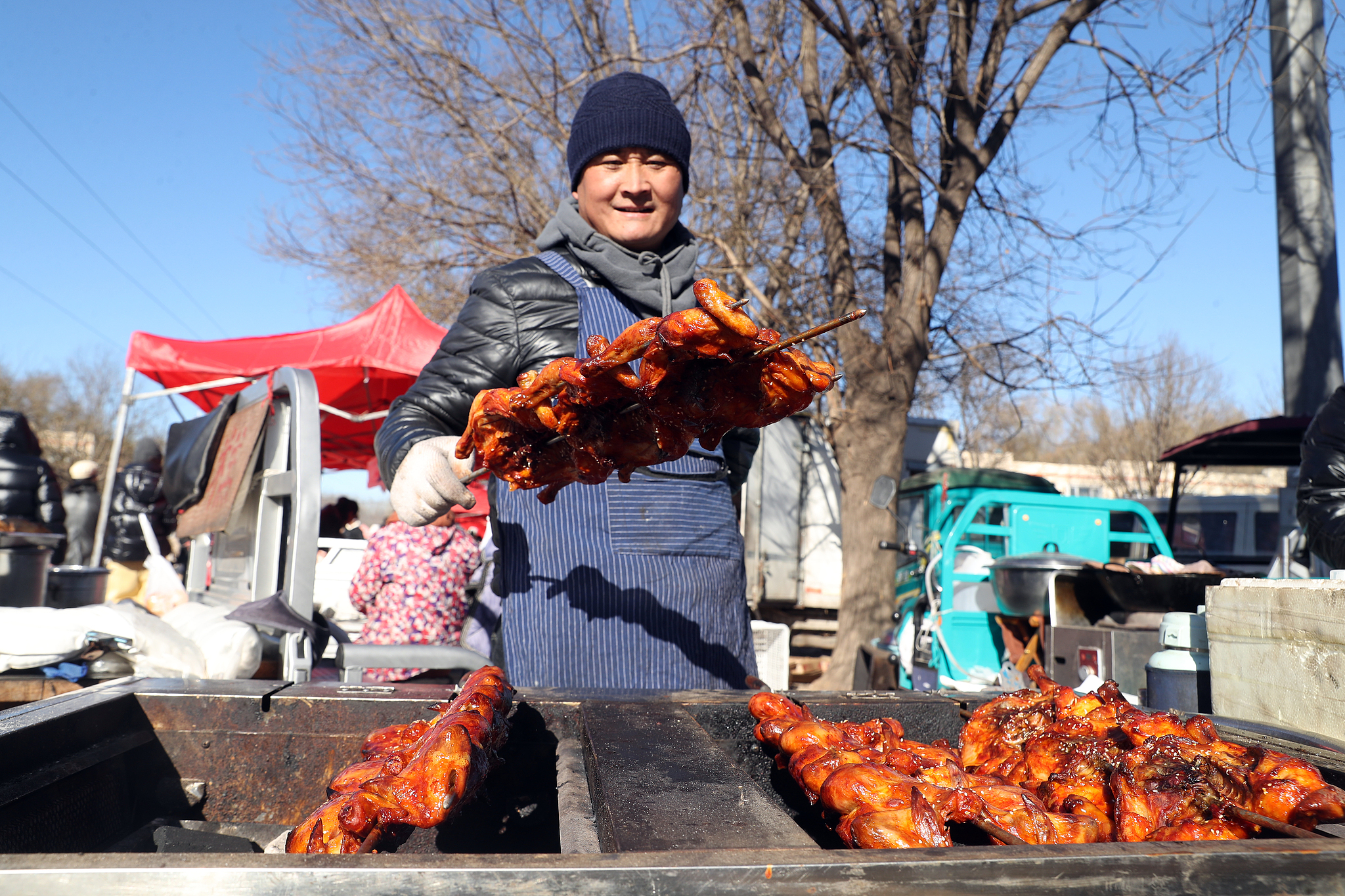 A vendor sells roasted chicken at a rural open-air market in Huoxian County, Tongzhou District, Beijing, December 2, 2024. /CFP