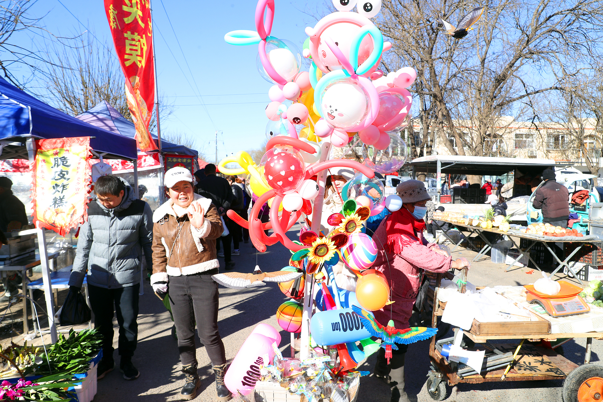 A vendor sells balloons at a rural open-air market in Huoxian County, Tongzhou District, Beijing, December 2, 2024. /CFP