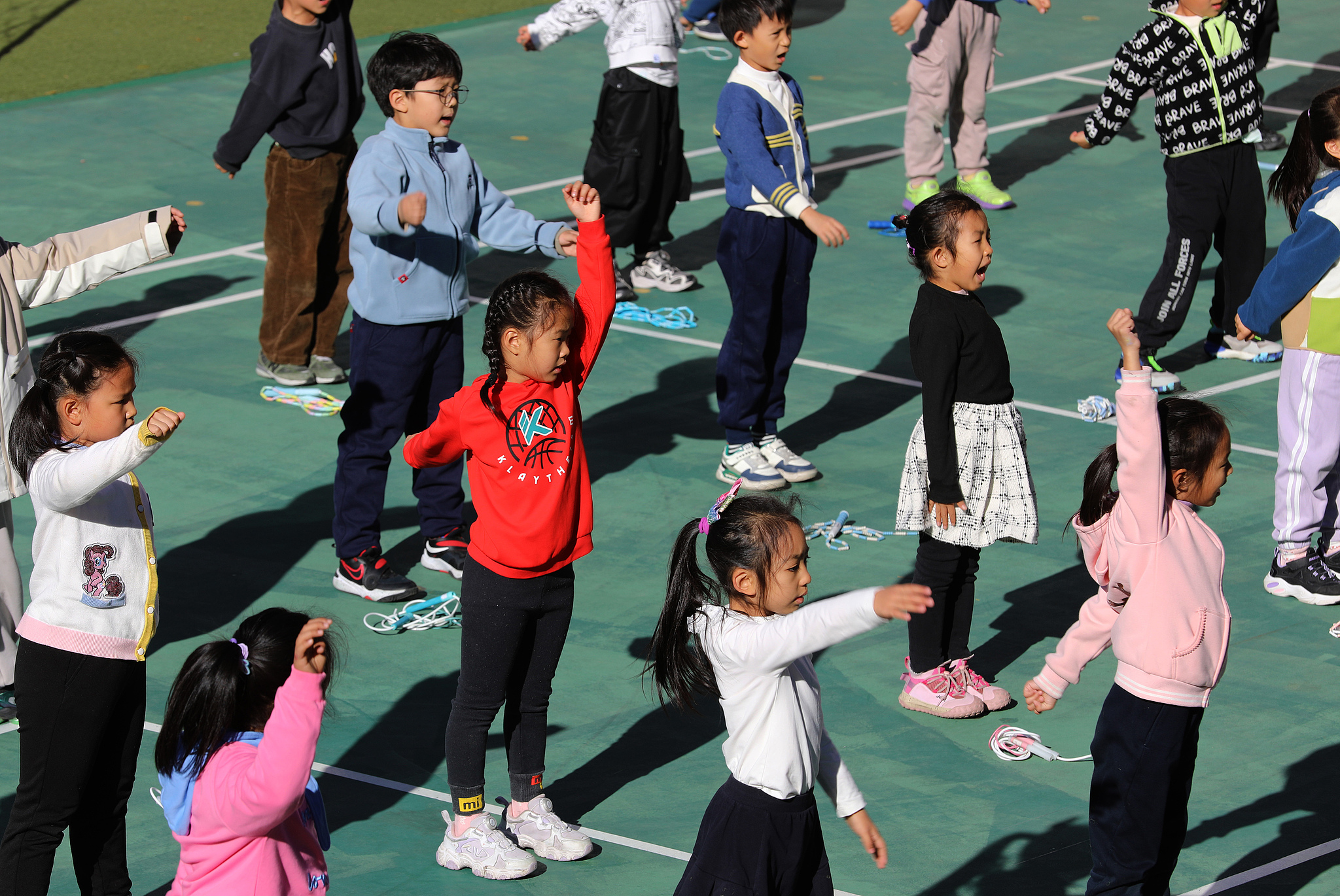 Schoolchildren warm up their bodies at the Beijing Chaoyang District Experimental Primary School, Beijing, November 21, 2024. /CFP