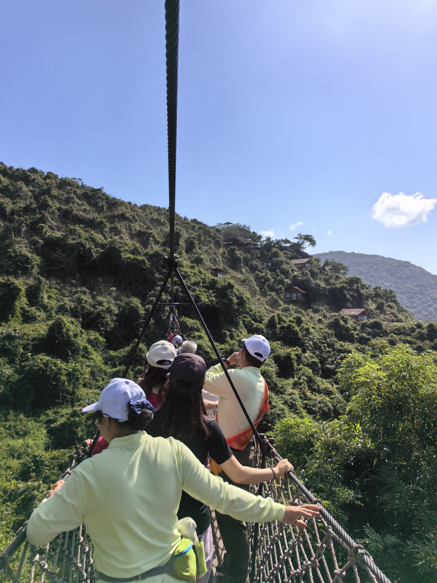 Tourists walk across the Crossing Dragon Rope Bridge at Yalong Bay Tropical Paradise Forest Park in Sanya, south China's Hainan Province. /CGTN