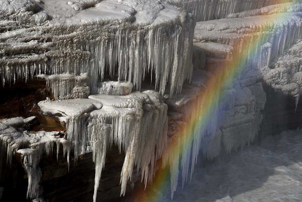 A photo taken on December 16, 2024 shows a rainbow appearing over the frozen rocky banks of the Hukou Waterfall seen from Yan'an, Shaanxi Province, China. /CFP