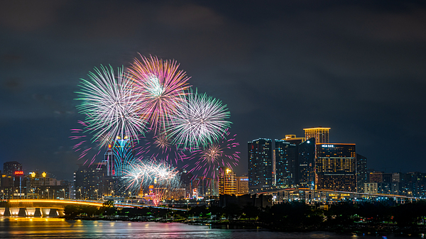 A dazzling fusion of brilliant fireworks and illuminated cityscapes lights up the night sky, where tradition meets modernity in spectacular harmony, China's Macao Special Administrative Region (SAR), December 16, 2024. /CFP