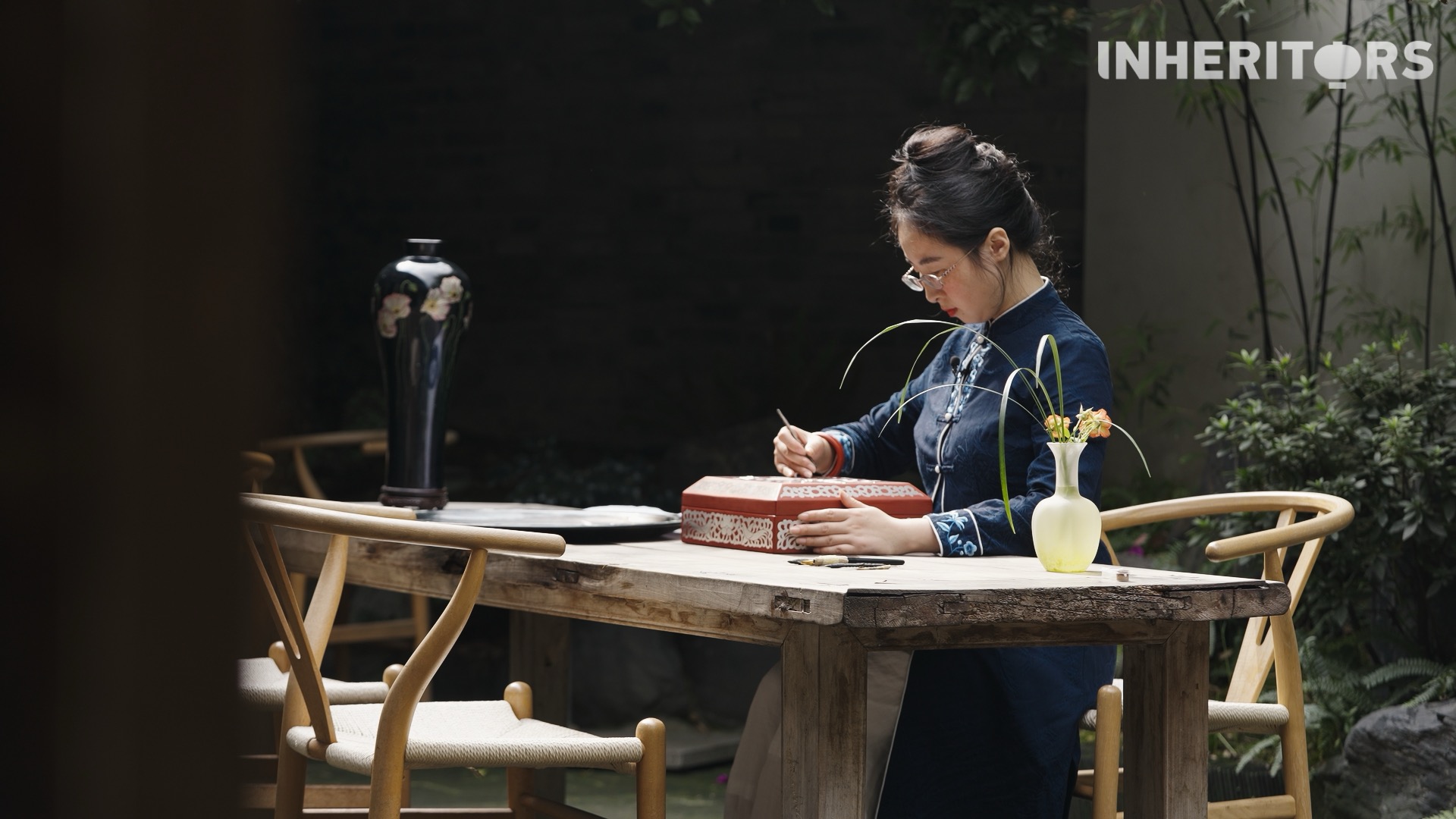 An artisan uses a specially designed engraving needle to draw thread-like lines into the metal foil inlaid in a piece of lacquerware. /CGTN