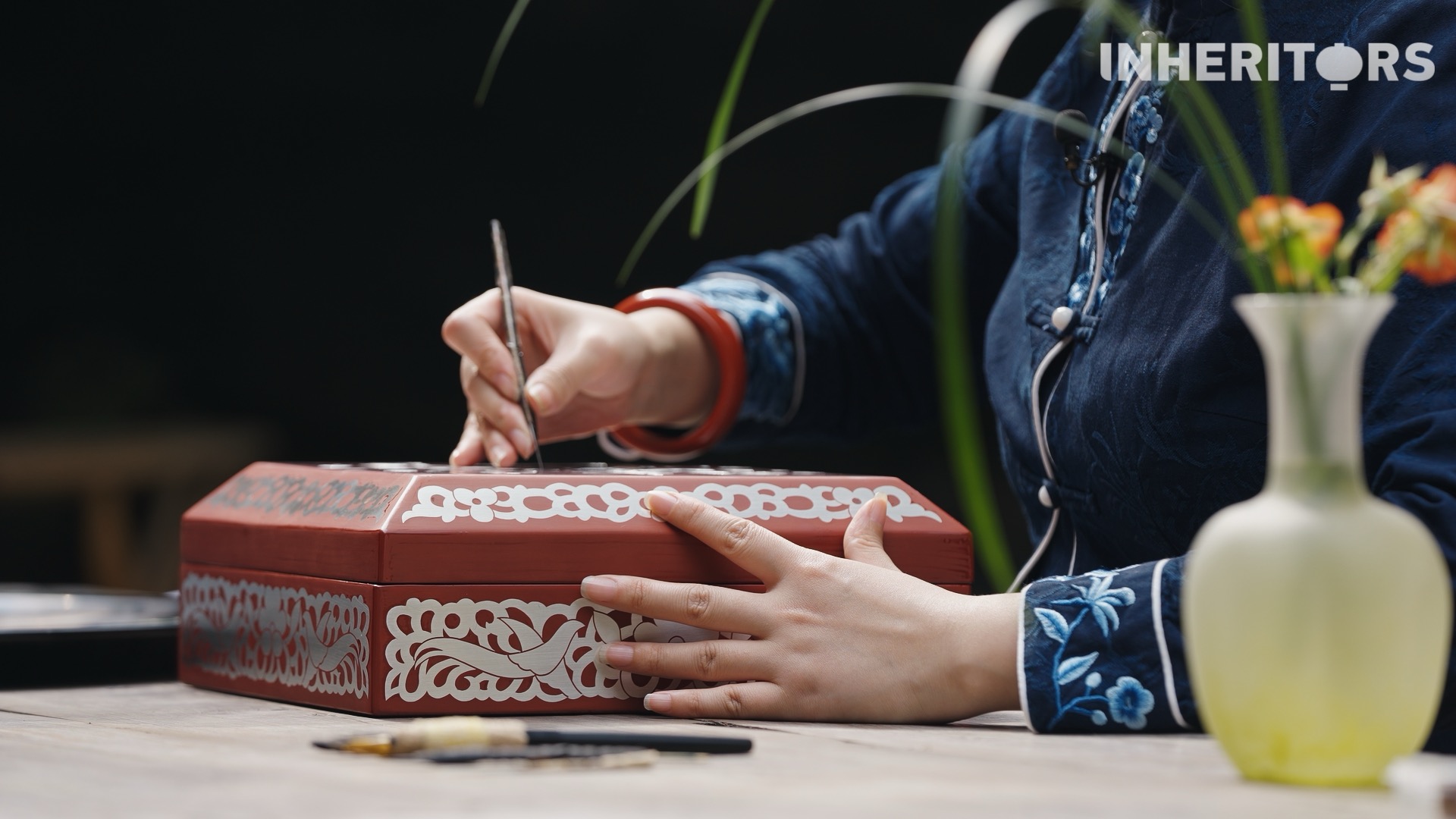 An artisan uses a specially designed engraving needle to draw thread-like lines into the metal foil inlaid in a piece of lacquerware. /CGTN