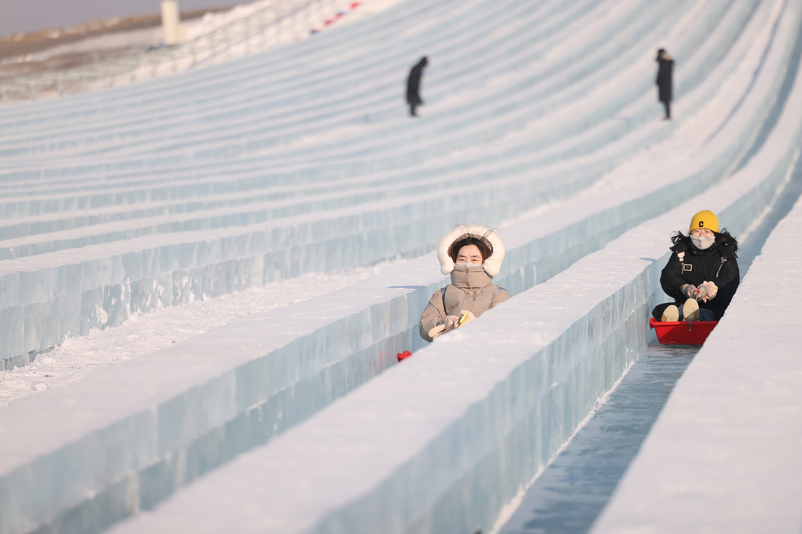 Visitors experience the Super Ice Slide, one of the most popular attractions at the Harbin Ice and Snow World in Harbin, Heilongjiang Province on December 21, 2024. /CFP