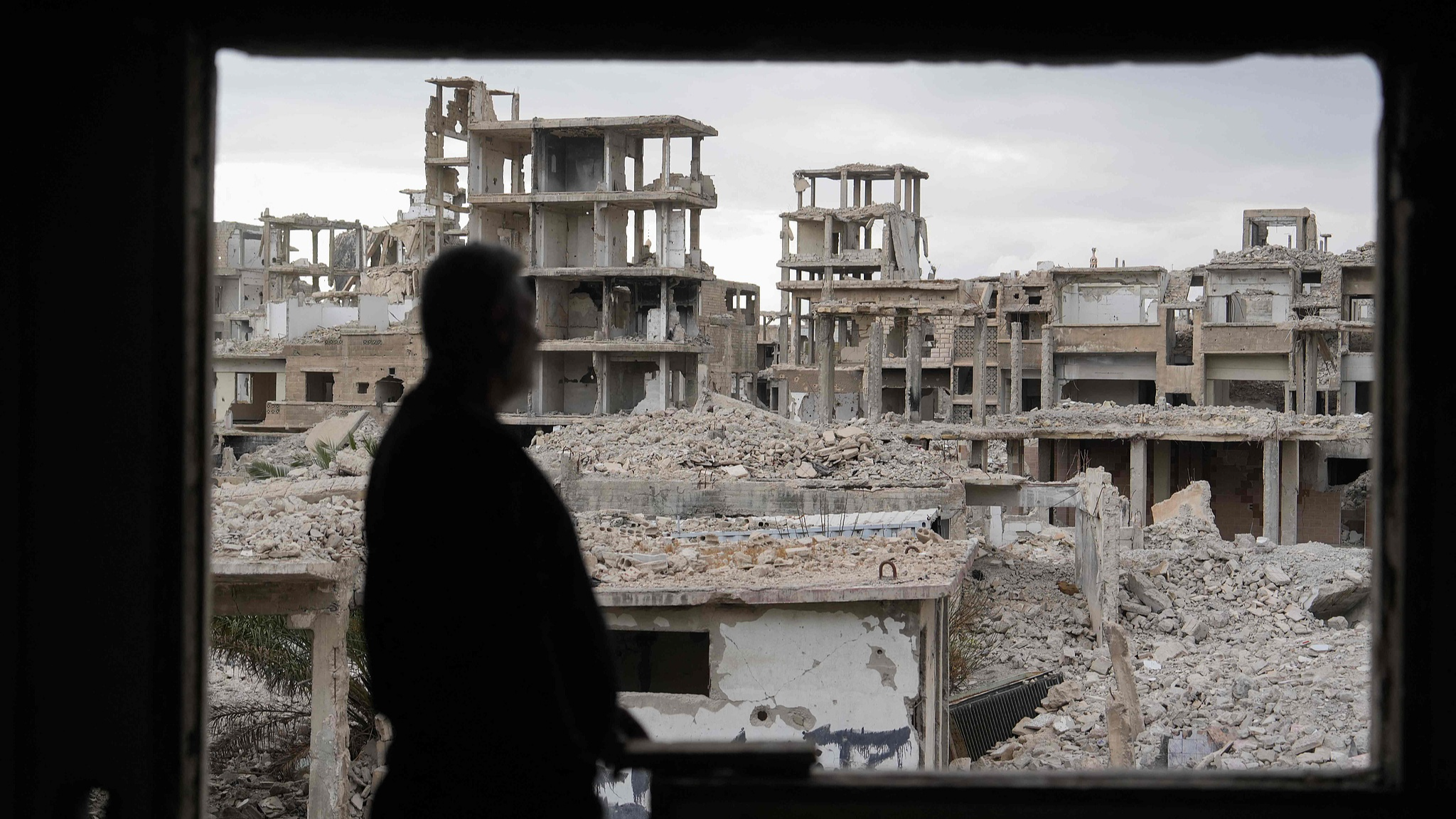 A man looks out to the devastation while clearing rubble and debris from a house in south of Damascus, Syria, December 22, 2024. /CFP