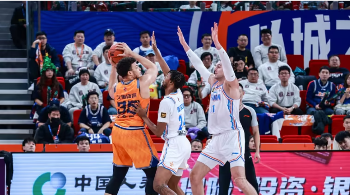 Kenneth Lofton Jr. (L) of the Shanghai Sharks is marked by defenders of the Fujian Sturgeons in the game in east China's Shanghai Municipality, December 25, 2025. /Xinhua