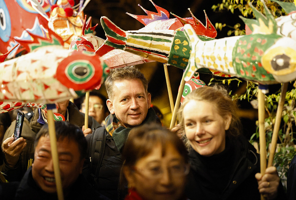 Dutch visitors dance together with locals during a fish lantern parade in Xixinan Ancient Village on December 26, 2024. /CFP