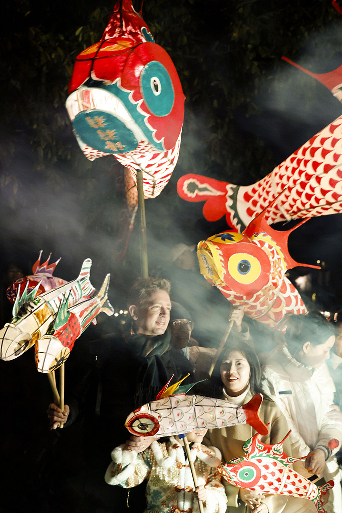 Dutch visitors dance together with locals during a fish lantern parade in Xixinan Ancient Village on December 26, 2024. /CFP