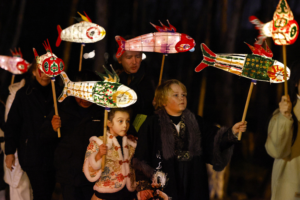 Dutch visitors dance together with locals during a fish lantern parade in Xixinan Ancient Village on December 26, 2024. /CFP