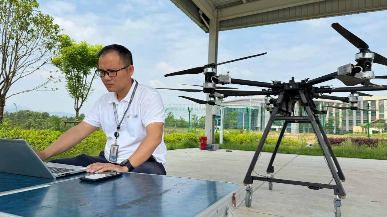 Zhou Guojun operates a drone on a computer. /CMG