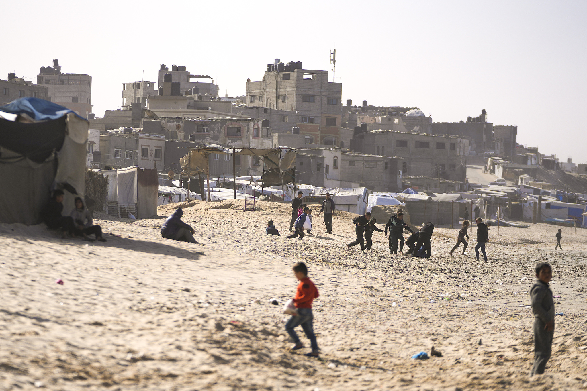 Children play on the sand in a camp for internally displaced Palestinians at the beachfront in Deir al-Balah, Gaza Strip, December 27, 2024. /CFP