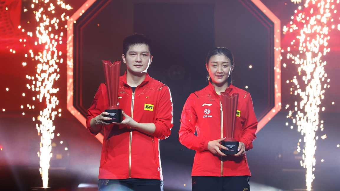 China's Fan Zhendong (L) and Chen Meng celebrate with the men's and women's championship trophies after winning their respective singles finals at the WTT Singapore Smash in Singapore, March 20, 2022. /CFP