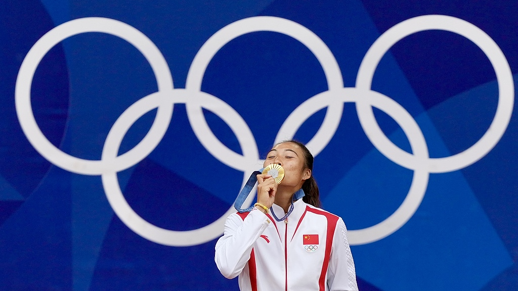 China's Zheng Qinwen kisses her gold medal after defeating Croatia's Donna Vekic during the Women's Singles tennis final at the Roland Garros stadium in Paris, France, August 3, 2024. /CFP