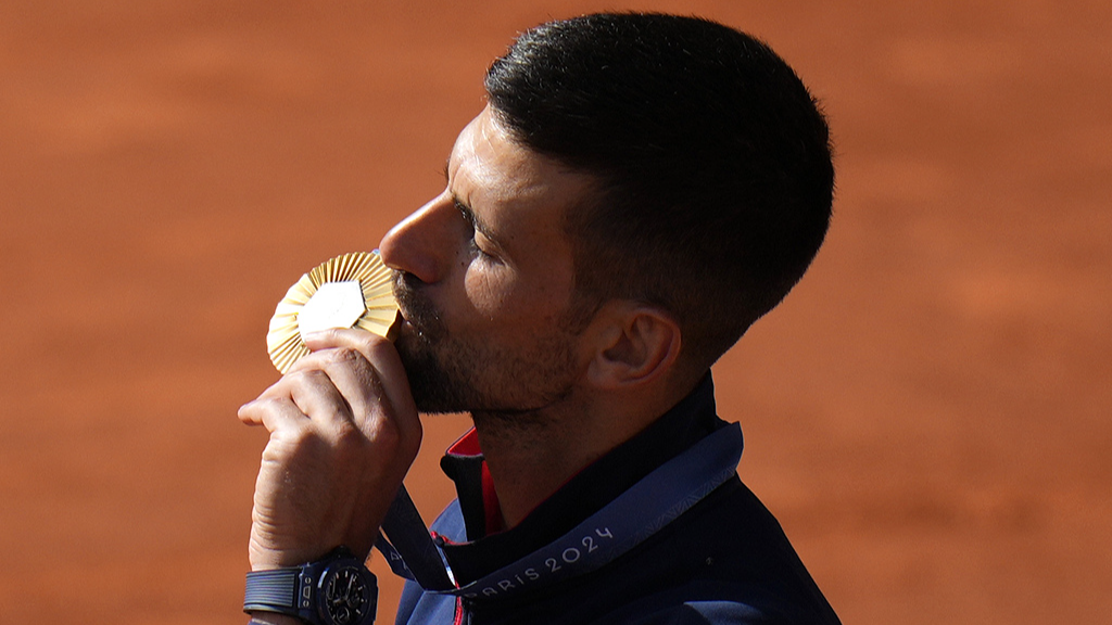 Serbia's Novak Djokovic kisses his gold medal after defeating Spain's Carlos Alcaraz in the men's singles tennis final at the Roland Garros stadium during the 2024 Summer Olympics in Paris, France, August 4, 2024. /CFP