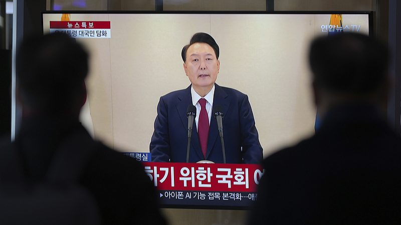 People watch a TV screen showing a live broadcast of South Korean President Yoon Suk-yeol's announcement at the Seoul Railway Station in Seoul, South Korea, December 12, 2024. /CFP