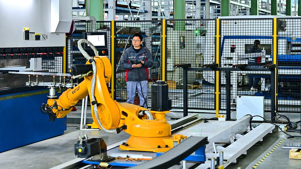 Industrial robots on the production line operate in cycles, while workers process new power transmission and transformation equipment, Fuzhou City, southeast China's Jiangxi Province, December 12, 2024. /CFP