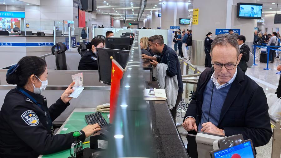 Border police officers check travelers' documents at the Shanghai Pudong International Airport in east China's Shanghai, March 14, 2024. /Xinhua