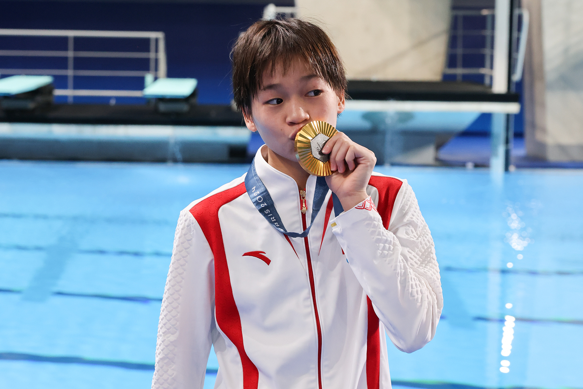 China's Quan Hongchan kisses her gold medal after winning the women's 10m platform final at the Summer Olympics in Paris, France, August 6, 2024. /CFP