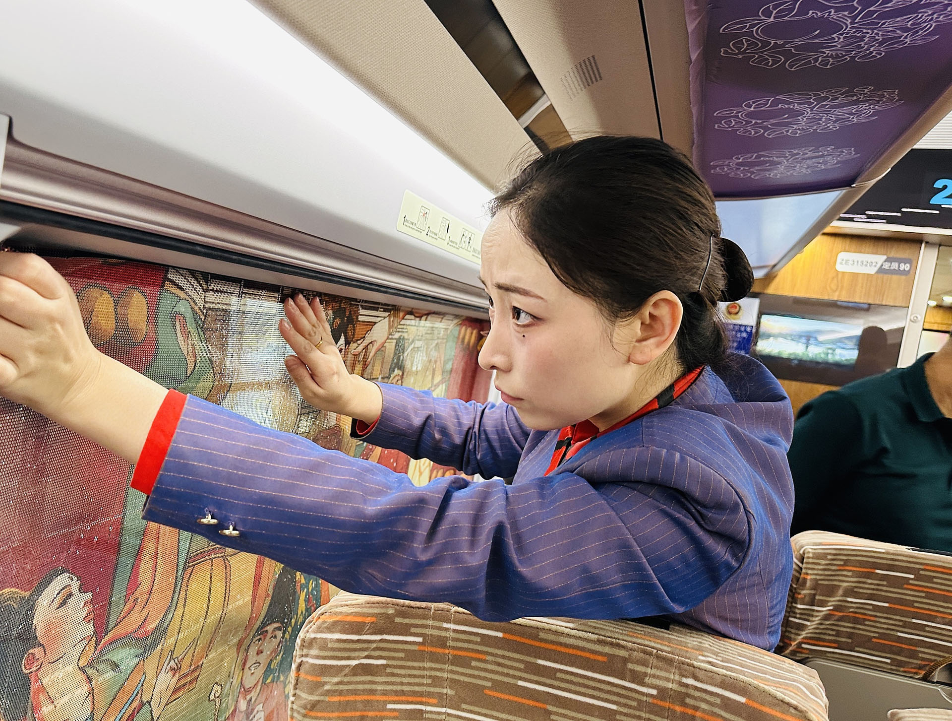 A railway employee in northwest China's Xi'an City decorates a train car ahead of its first trip to China's Hong Kong, January 3, 2025. /CFP