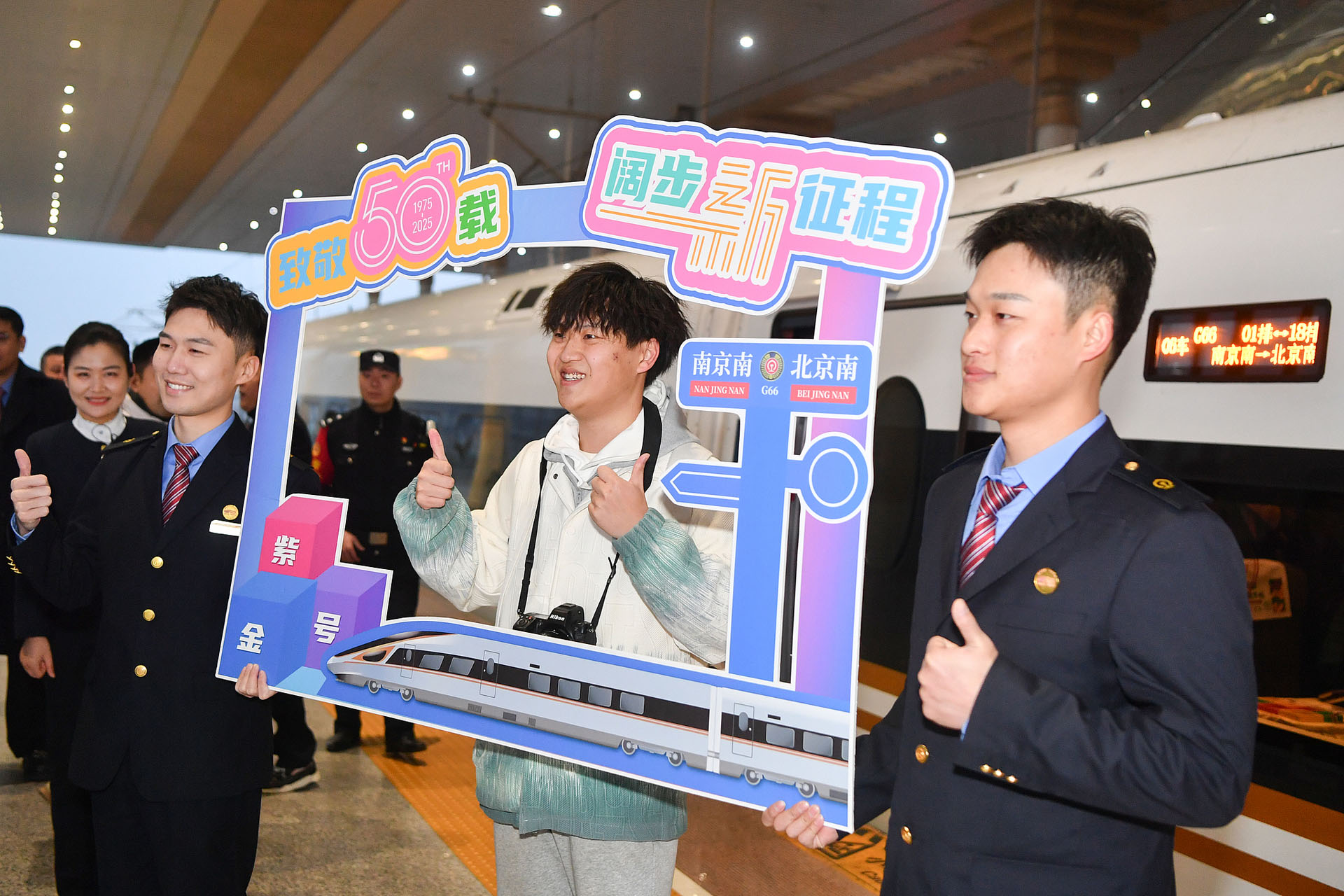 A passenger and two railway employees pose for a photo at Nanjing South Station, east China's Jiangsu Province, January 5, 2025. /CFP