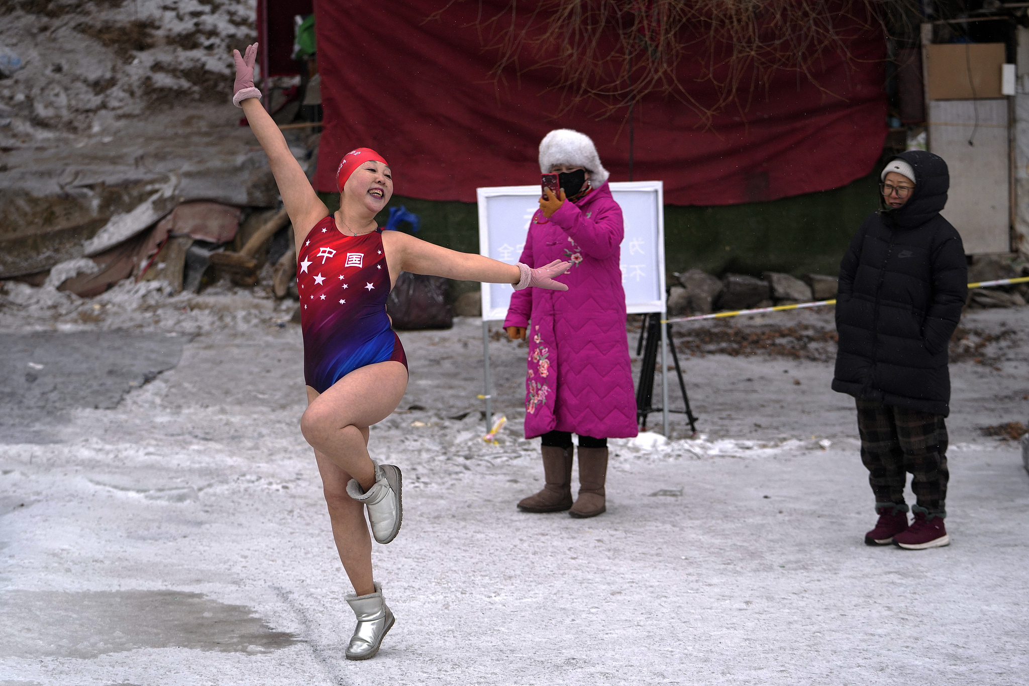 A woman poses as she prepares to jump into a pool carved out of the frozen Songhua River in Harbin, Heilongjiang Province on January 7, 2025. /Andy Wong/AP/VCG