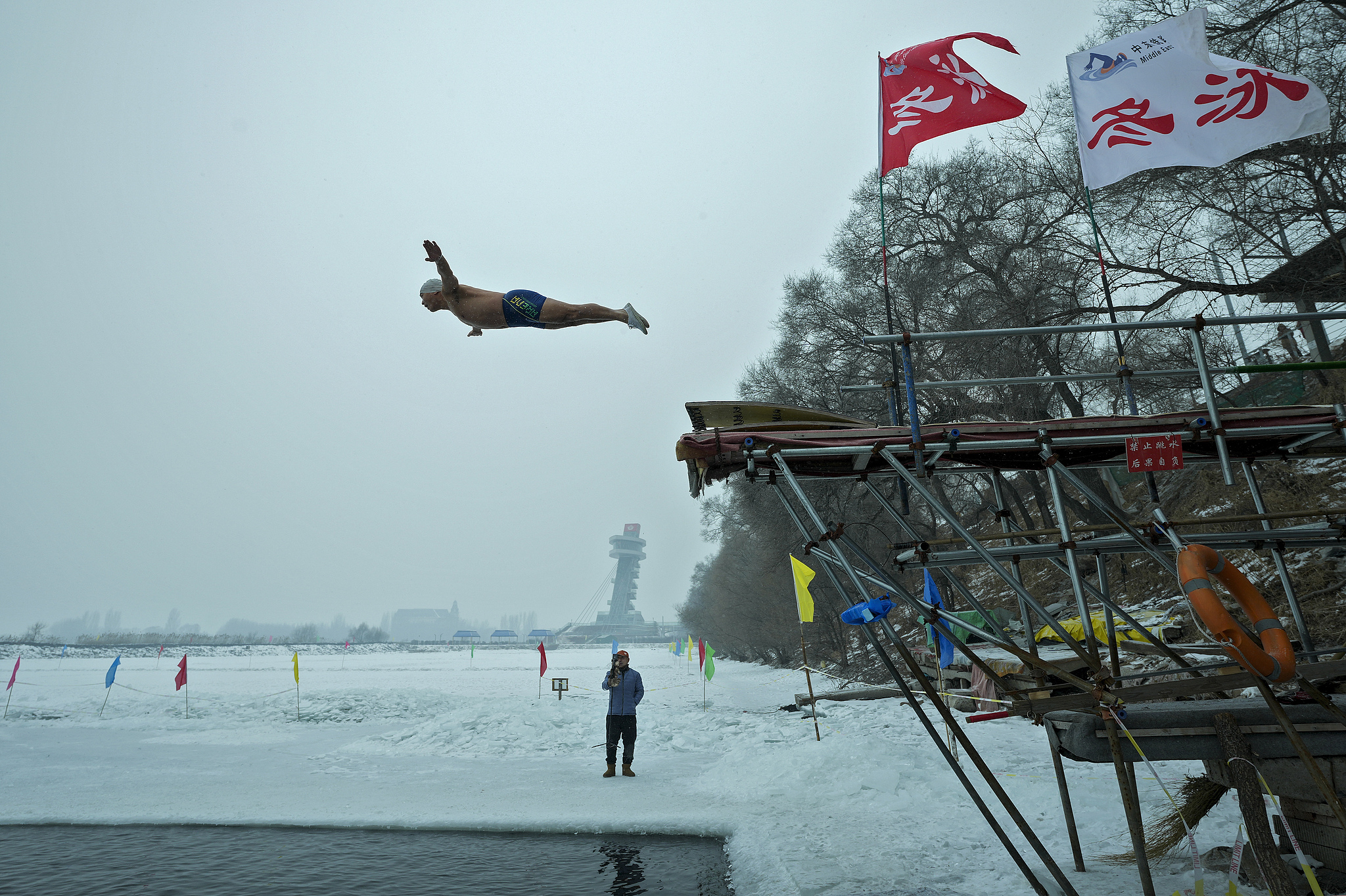 A man jumps into a pool carved out of the frozen Songhua River in Harbin, Heilongjiang Province on January 7, 2025. /Andy Wong/AP/VCG