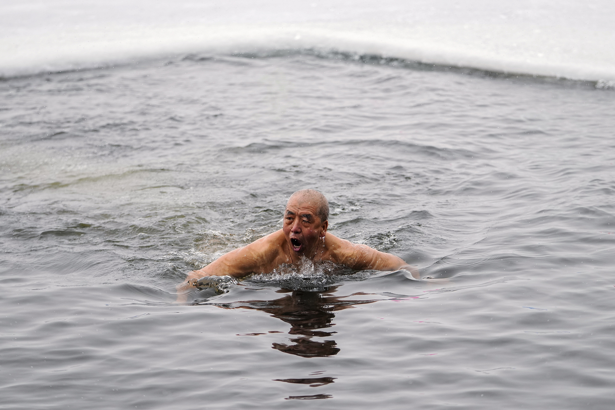 A man swims in a pool carved out of the frozen Songhua River in Harbin, Heilongjiang Province on January 7, 2025. /Andy Wong/AP/VCG