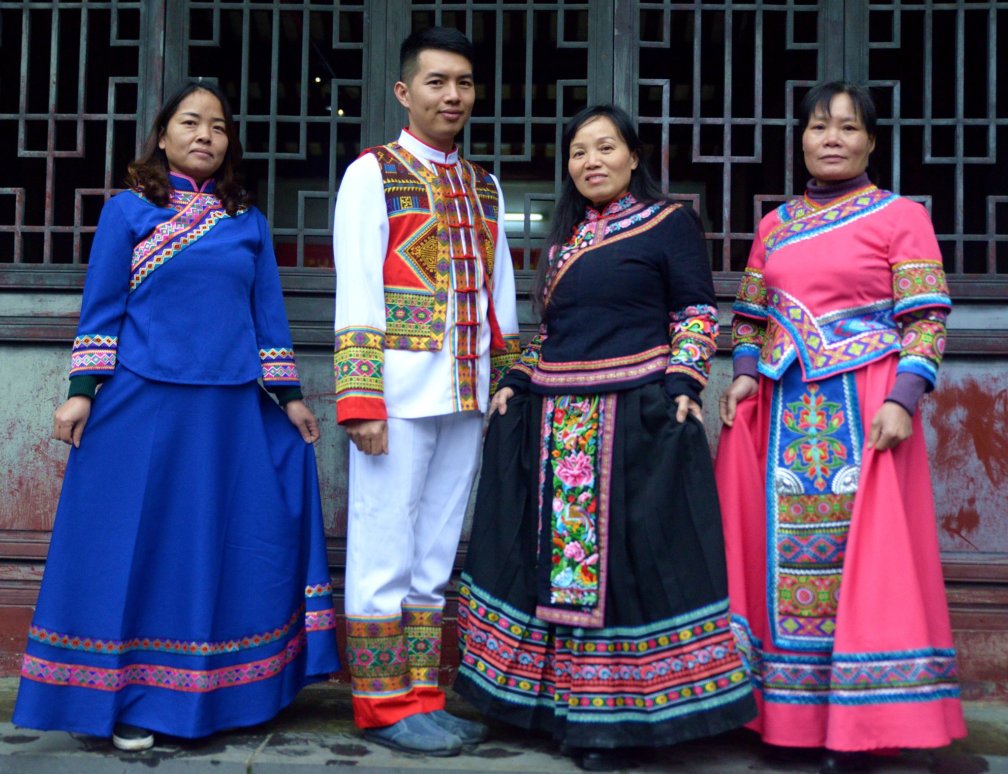 Liang Hengyuan, an inheritor of Zhuang brocade techniques, showcases the ethnic clothing designed by him with three other Zhuang brocade weavers. /CFP