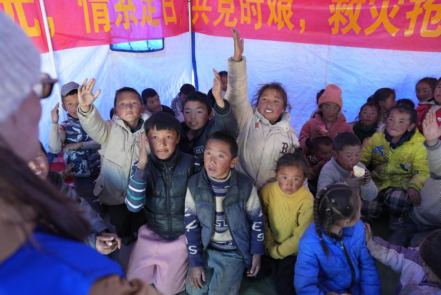 Children raise hands to answer questions during a psychology class given by a social work service center at a resettlement site for quake-affected residents in a village in Dingri County in Xigaze, southwest China's Xizang Autonomous Region, Jan. 8, 2025. /Xinhua