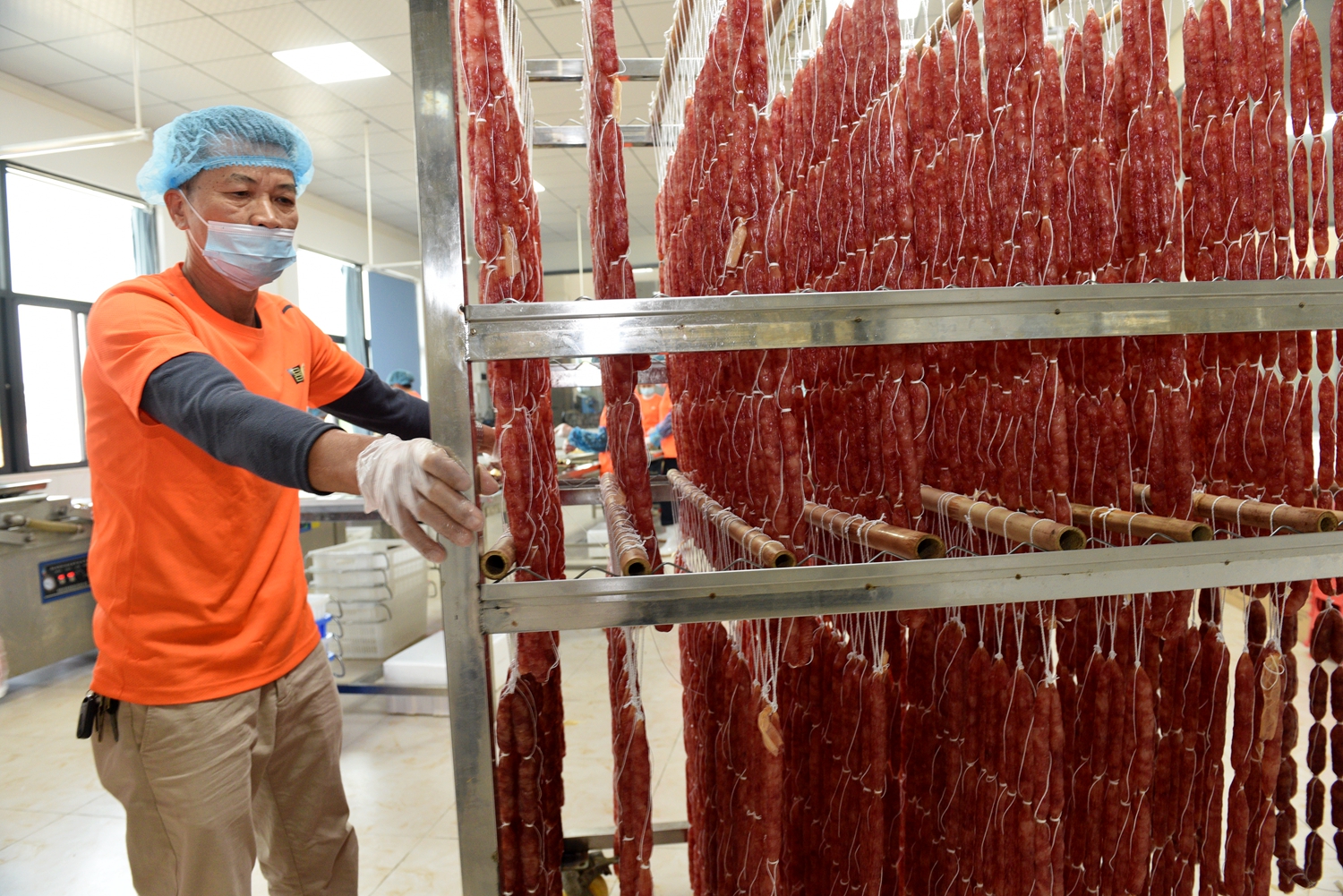 Cured sausages are prepared at a food factory in Tunchang, Hainan Province on January 6, 2025. /Photo provided to CGTN