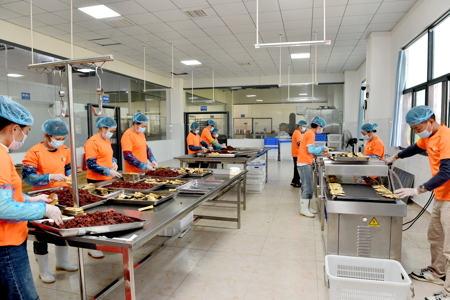 Worker are seen packing cured black pork jerky at a food factory in Tunchang, Hainan Province on January 6, 2025. /Photo provided to CGTN