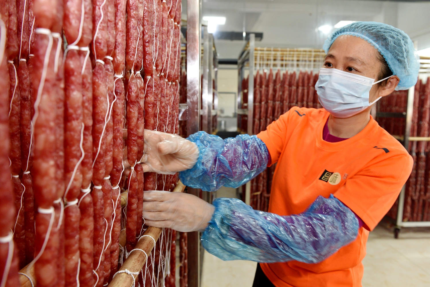 Cured sausages are prepared at a food factory in Tunchang, Hainan Province on January 6, 2025. /Photo provided to CGTN