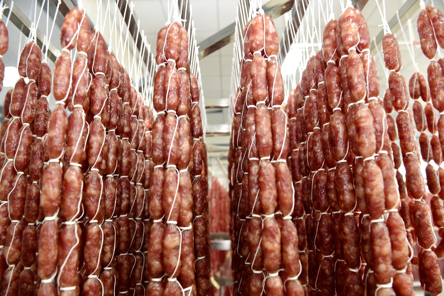 Cured sausages are prepared at a food factory in Tunchang, Hainan Province on January 6, 2025. /Photo provided to CGTN