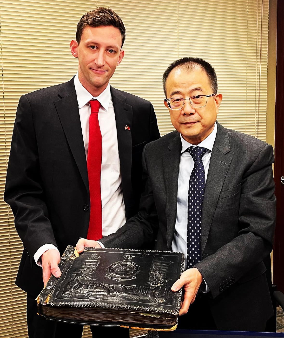 Evan Kail (left) gives an album to the Chinese Consulate General in Chicago. /Courtesy of Evan Kail
