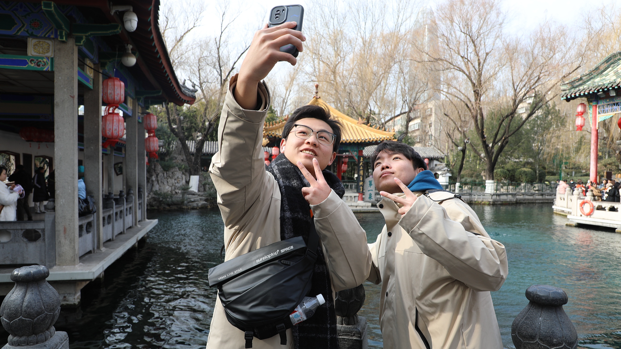 Taiwan youths take a photo in front of Baotu Spring in Jinan, east China's Shandong Province, January 14, 2025. /CFP