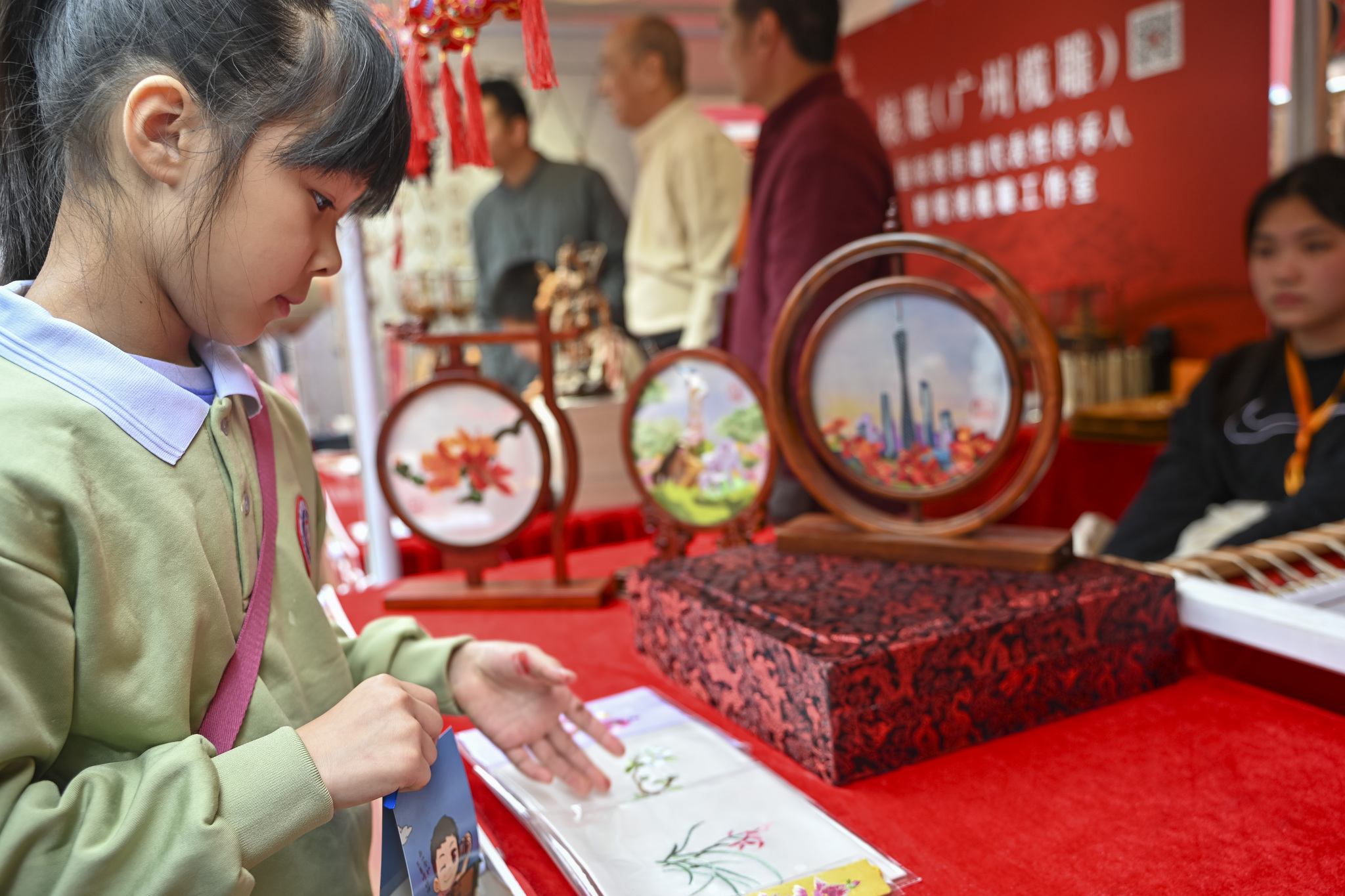 Seorang gadis menjelajahi kawasan warisan budaya takbenda di Pameran Kuil Guangfu di Guangzhou, Provinsi Guangdong pada 12 Februari 2025. /VCG