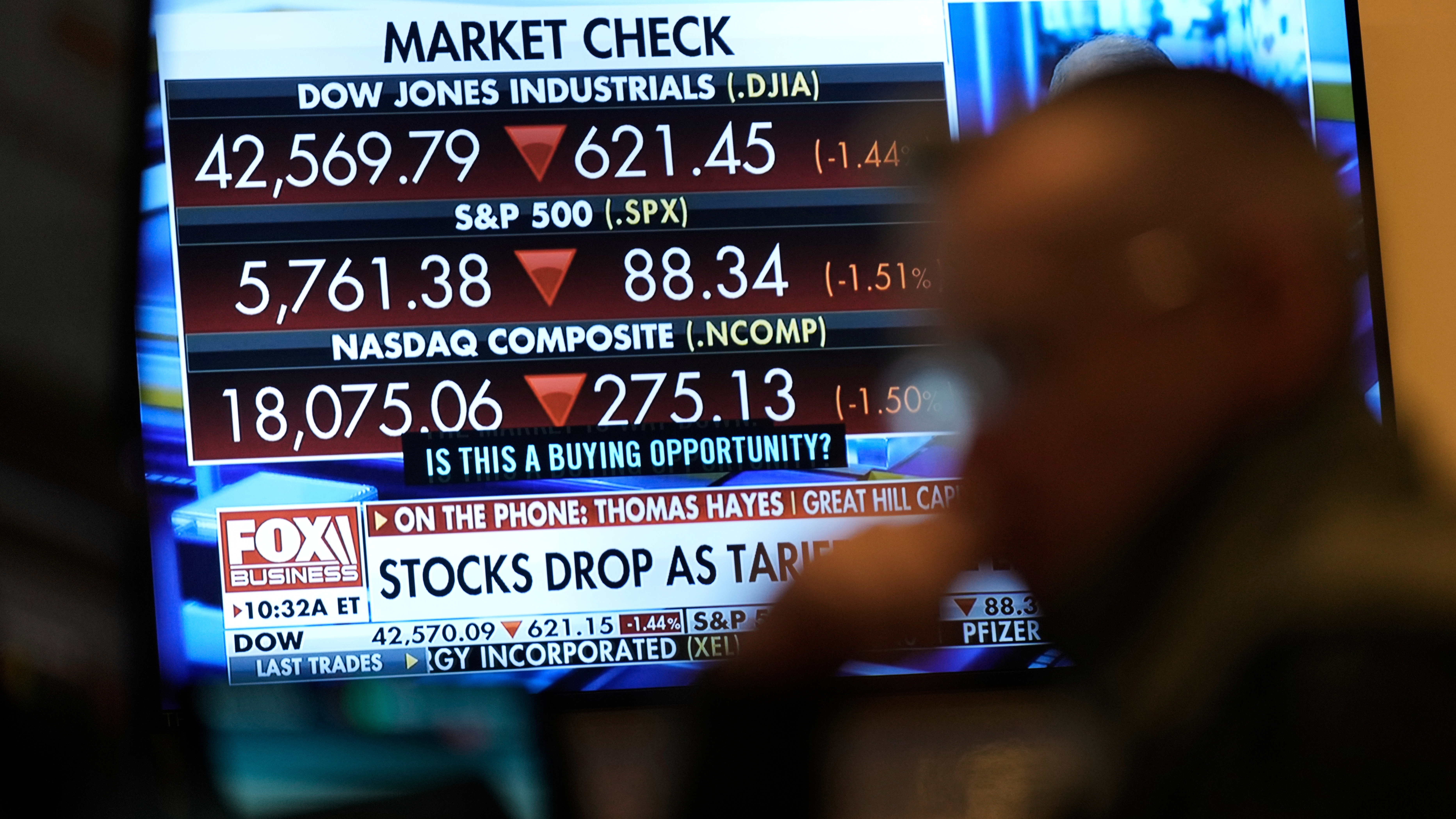 Financial news is displayed as people work on the floor at the New York Stock Exchange in New York, the U.S., March 4, 2025. /AP