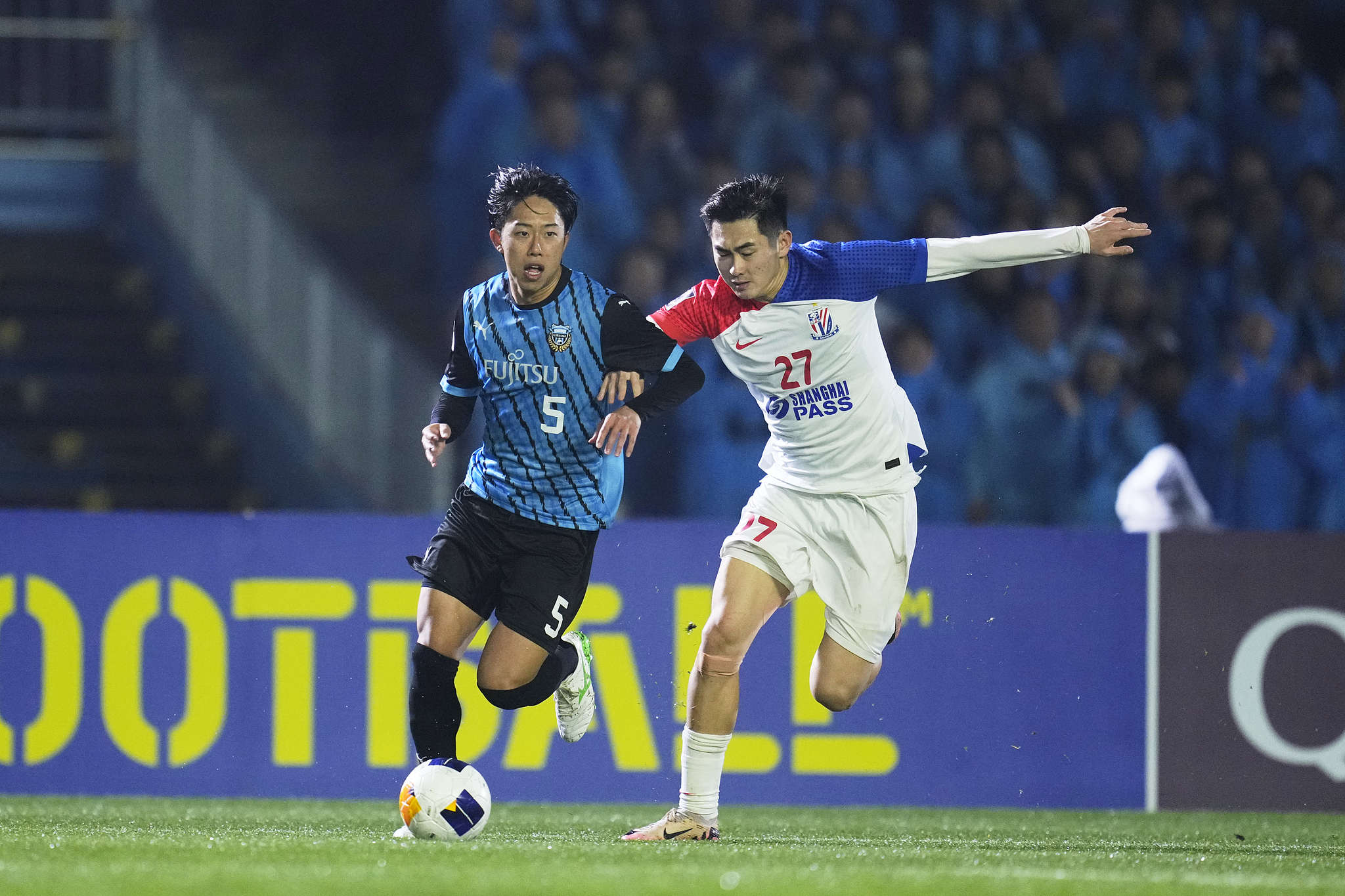 Asahi Sasaki (L) of Kawasaki Frontale dribbles in an Asian Football Confederation (AFC) Champions League Elite round of 16 second leg match against Shanghai Shenhua at Uvance Todoroki Stadium in Kanagawa, Japan, March 12, 2025. /VCG
