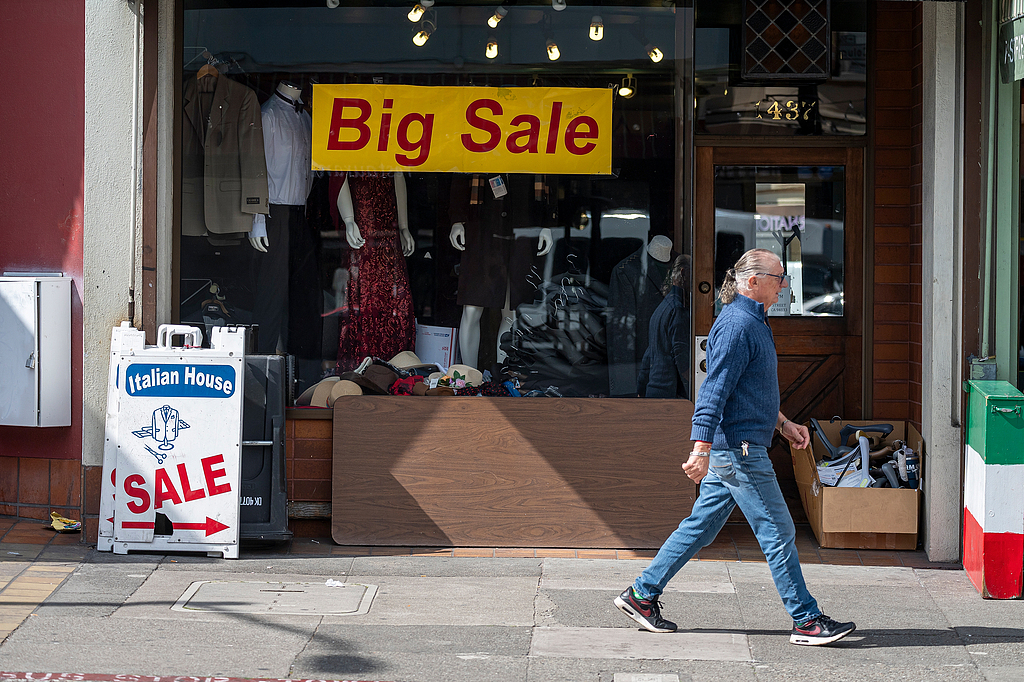 A pedestrian walks past sale signs outside a store in California, US, March 11, 2025. /VCG