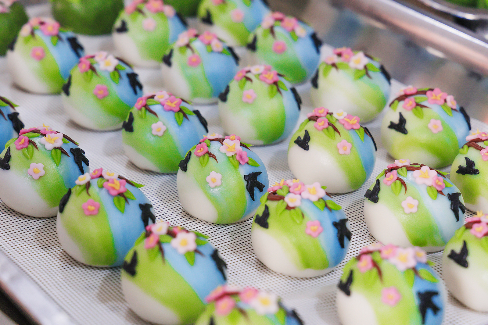 Qingming rice cakes featuring vibrant designs are seen at a workshop in Jinhua, Zhejiang Province on March 18, 2025. /VCG