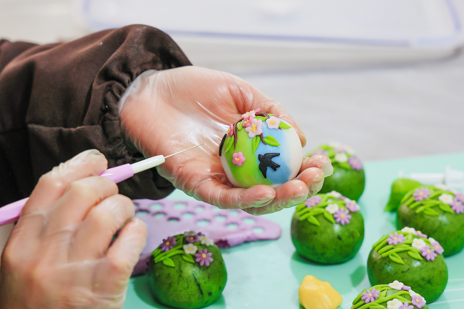 An artisan embellishes a Qingming rice cake with decorations at a workshop in Jinhua, Zhejiang Province on March 18, 2025. /VCG