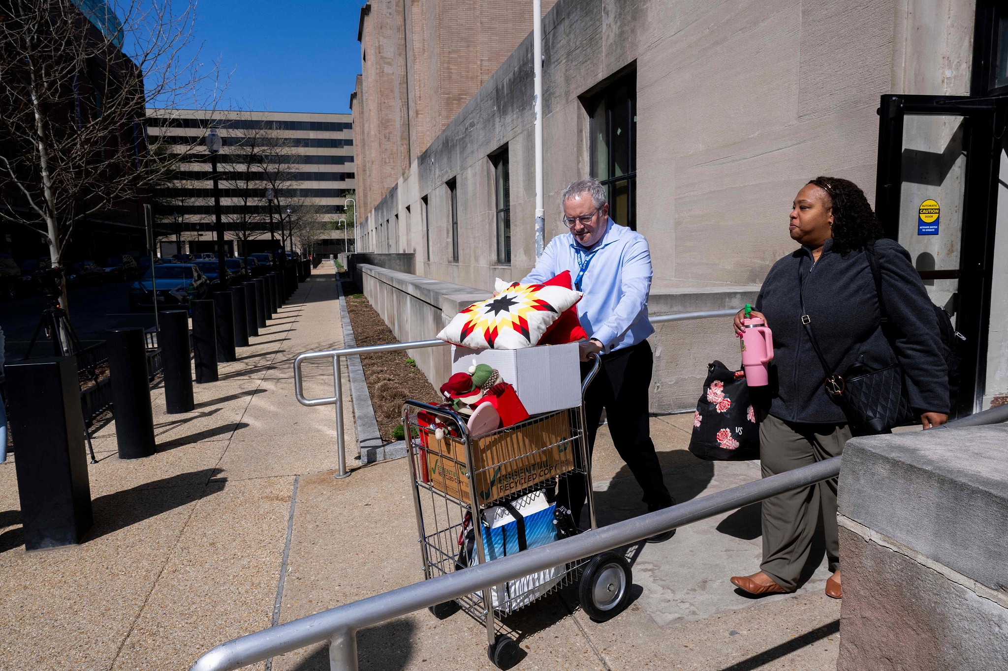 A federal worker, who lost her job, gets help carrying some of her belongings from her office at the Mary E. Switzer Memorial Building in Washington, DC, on April 1, 2025. /VCG