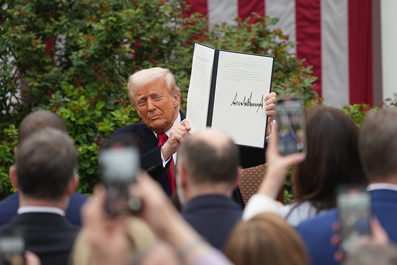 United States President Donald J Trump displays the signed Executive Order after his announcement of 