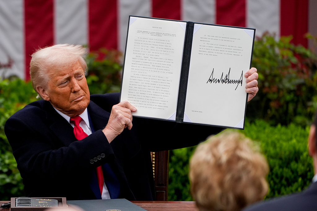 US President Donald Trump displays a signed executive order after announcing a set of 