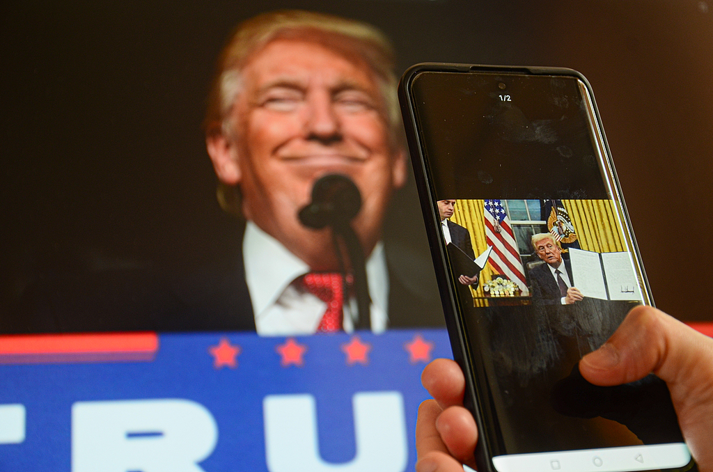 A Chinese citizen watches tariff-related news on a mobile phone in Jiangmen City, Guangdong Province, April 13, 2025. /VCG