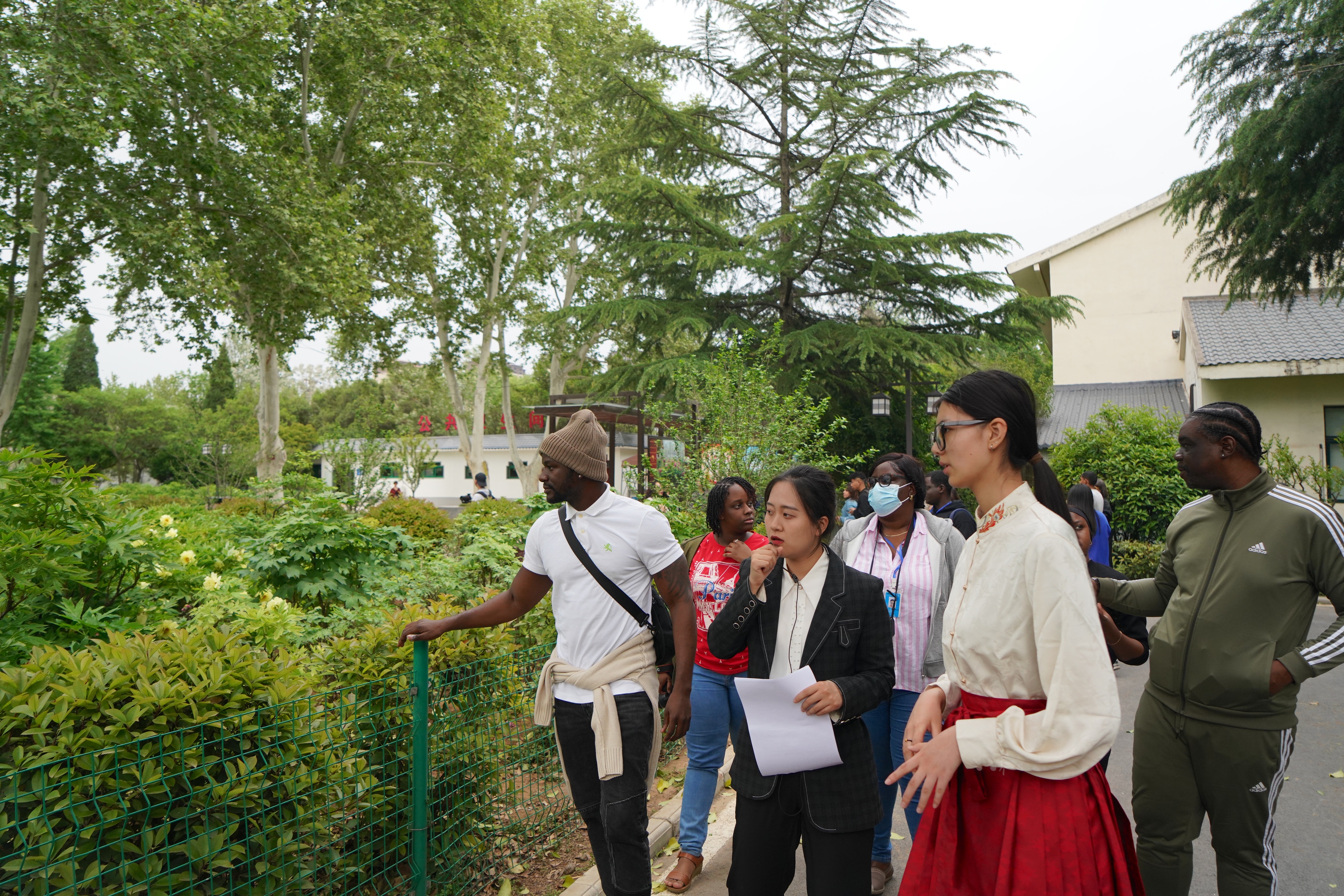 Members of the Latin America and Caribbean media delegation listen to an introduction to the peony flowers at the Luoyang National Peony Garden in central China's Henan Province on April 21, 2025. /CGTN