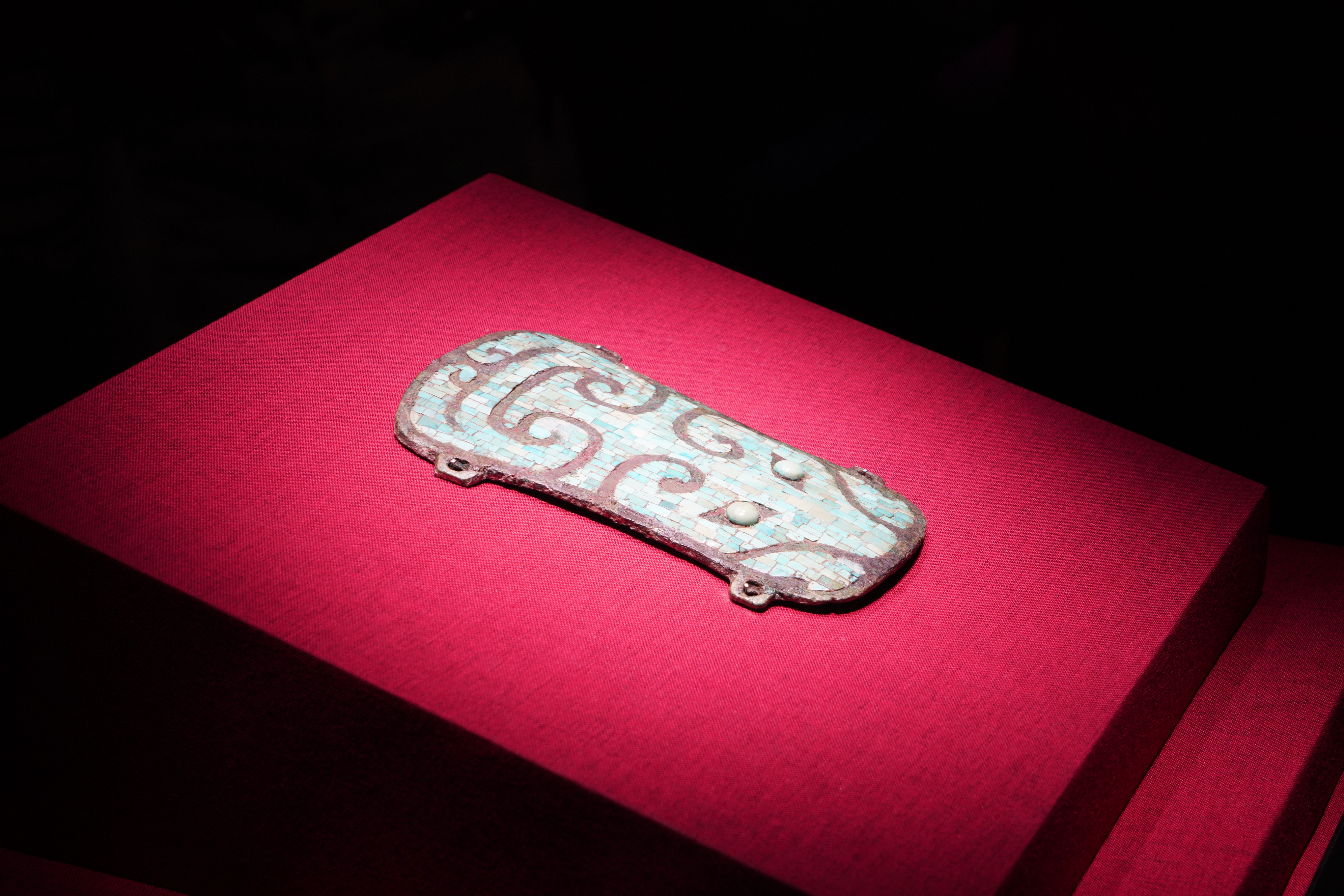 A turquoise-inlaid bronze plaque with a beast-mask motif is displayed at the Erlitou Site Museum of the Xia Capital in Luoyang, Henan Province, on April 22, 2025. /CGTN